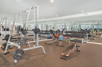 A gym with a variety of equipment including weights and exercise balls.